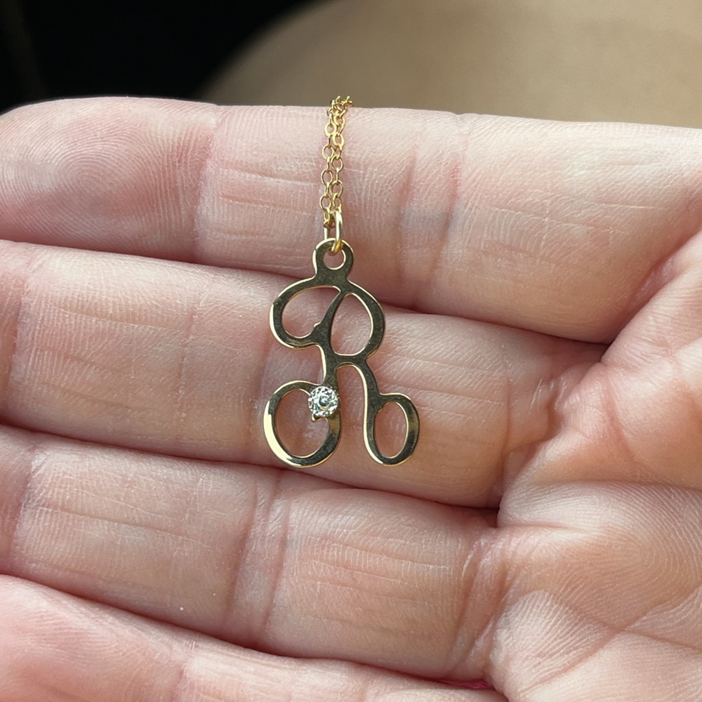 This R initial necklace with diamond chip is 14kt gold plated